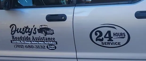 Close-up of the Sport Trac doors: Dusty's Roadside Assistance, the service list, (702) 680-3132, Se habla Español and the 24 Hours Service badge