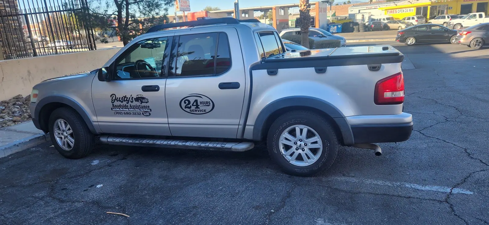 Dusty's silver Ford Explorer Sport Trac in Las Vegas, doors lettered Lock-Outs, Tire Change, Battery Jumps, Fuel Delivery and 24 Hours Service