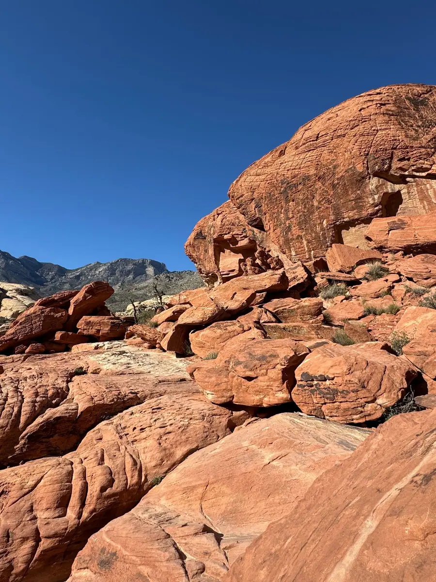 Red sandstone boulders at Red Rock Canyon under a deep blue sky, west of Summerlin