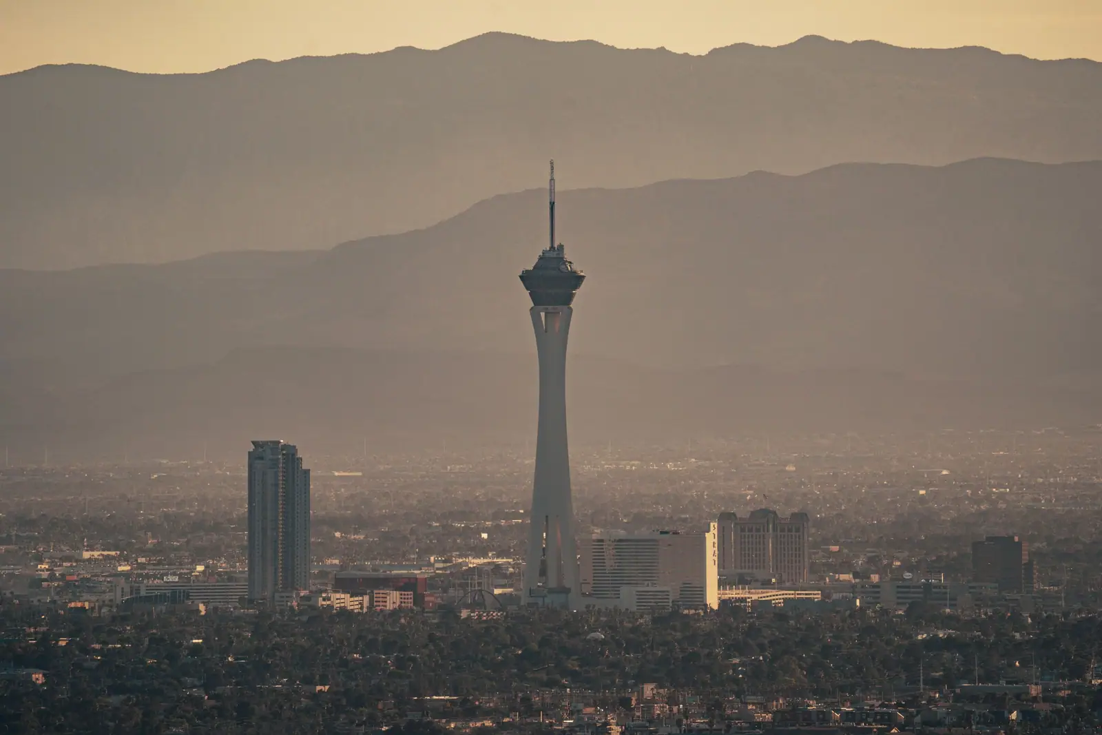 The Strat tower and downtown Las Vegas in haze with the mountains behind